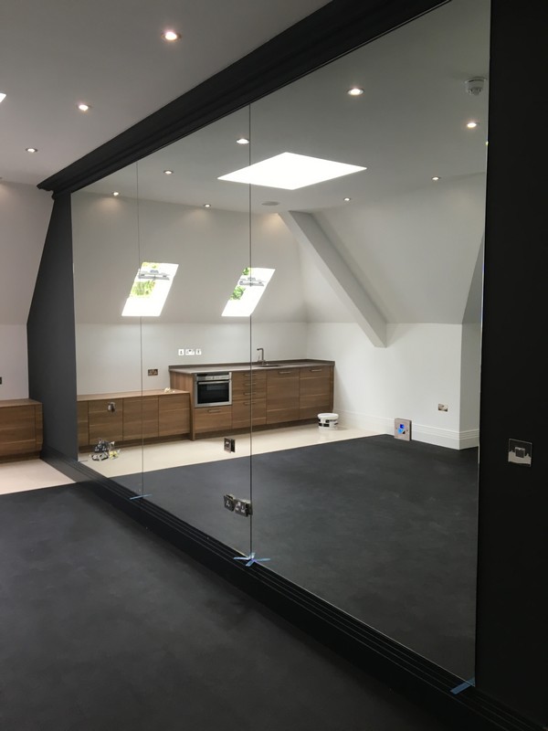 Frameless glass partition in loft conversion by Waterloo glaziers